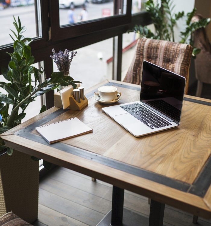 laptop-with-notepad-cafe-table